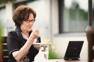 A senior resident having a meal by a remote care device.