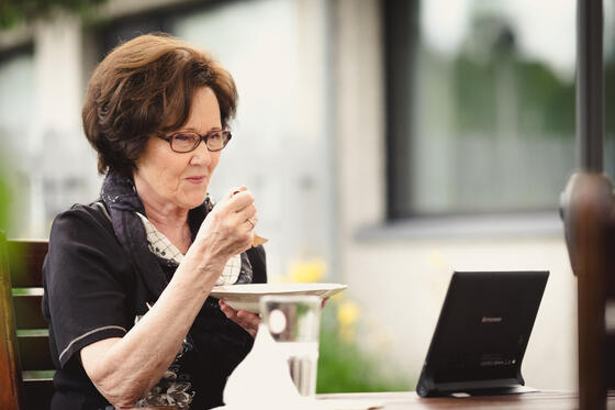 A senior resident having a meal by a remote care device.