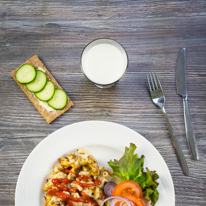 An example school meal containing macaroni and minced meat casserole, salad, a drink and crispbread.