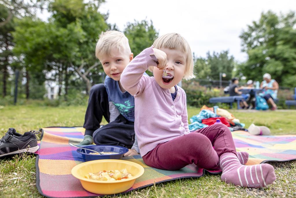 Barn äter i en lekpark i Helsingfors sommaren 2020.