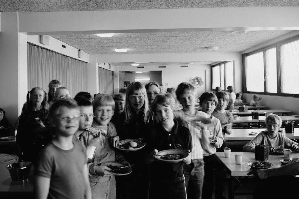 Oppilaat ruokalautastensa kanssa Puotilan ala-asteella 1984. Kuva: Kari Hakli, Helsingin kaupunginmuseo