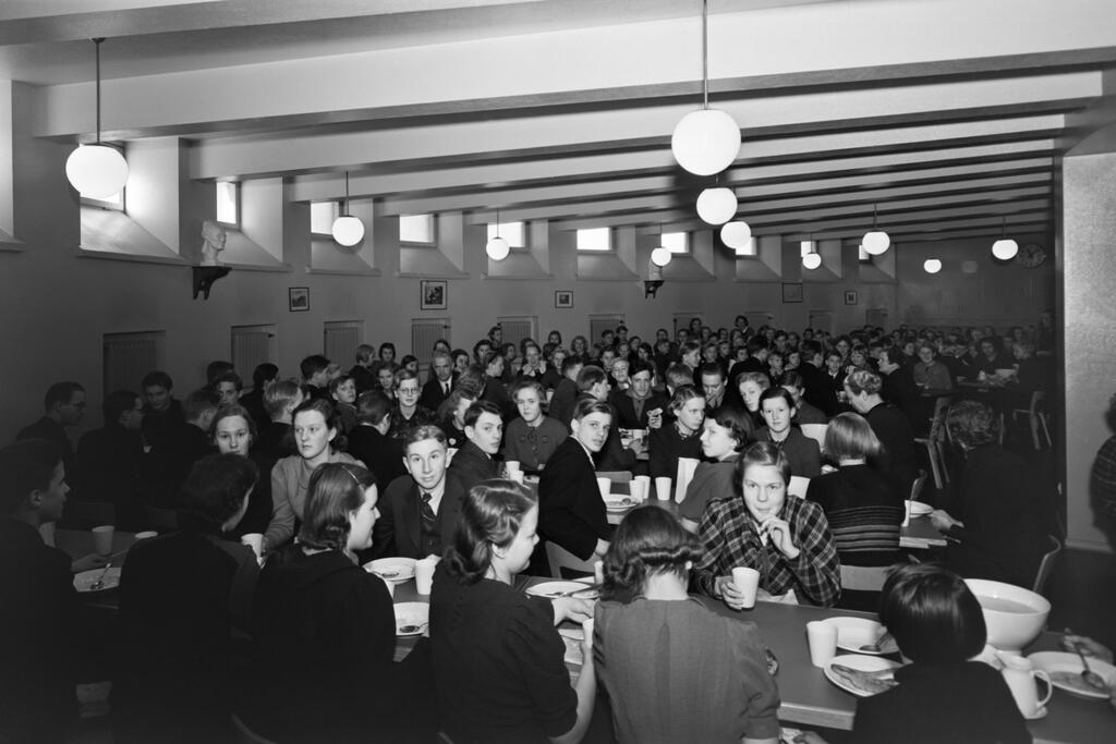 Suomalaisen yhteiskoulun oppilaat ovat syömässä ruokasalissa uudessa koulurakennuksessa Nervanderinkadulla 1938. Kuva: Aarne Pietiläinen Oy, Helsingin kaupunginmuseo